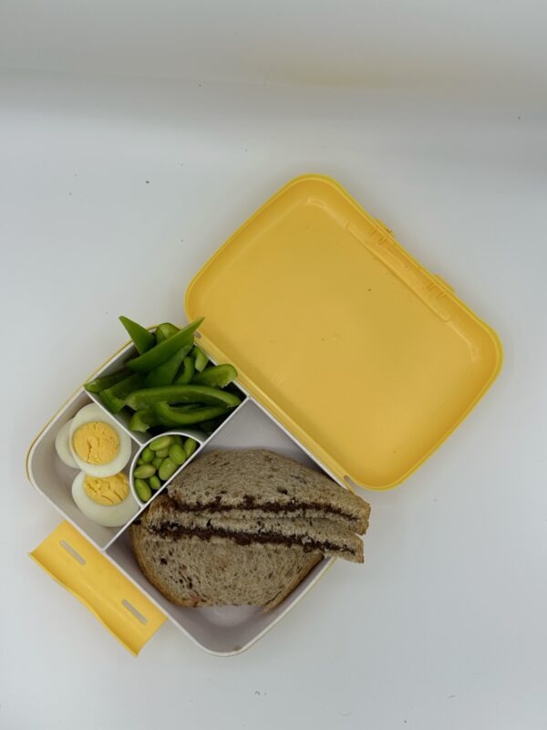 NjaNja gezonde lunchbox op school geleverd: boterham notenpasta, ei, paprika, edamame