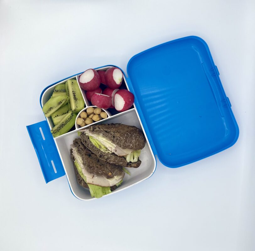 NjaNja gezonde lunchbox op school geleverd: broodje caesar, kiwi, radijs, kikkererwten