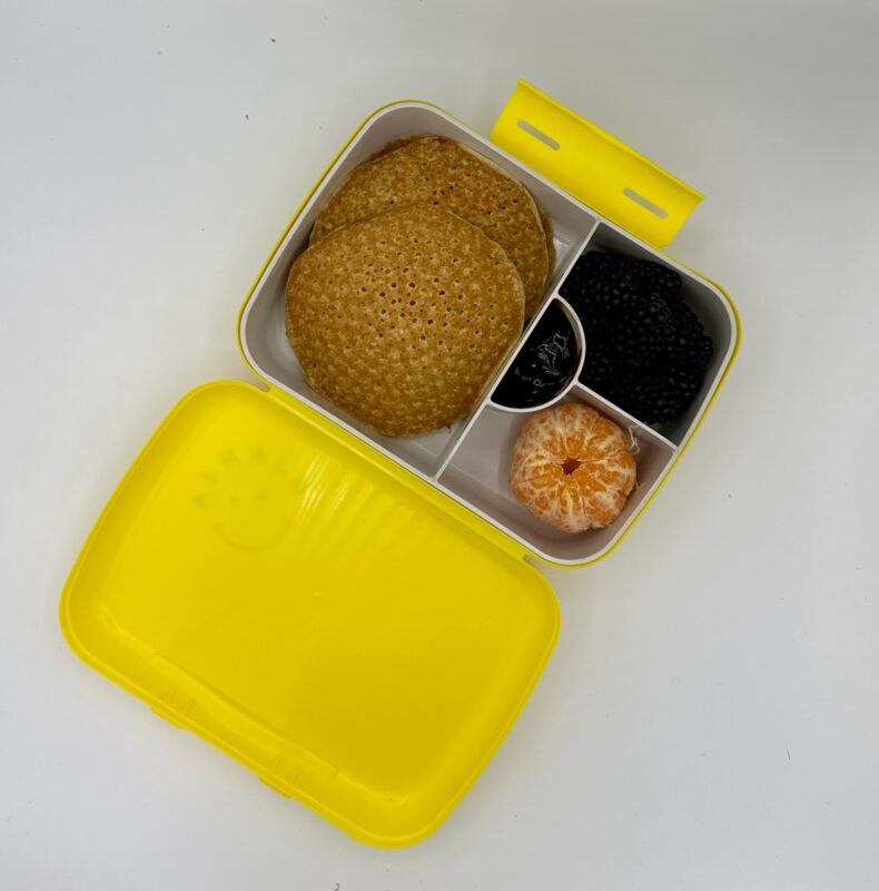 NjaNja gezonde lunchbox op school geleverd: mini pannenkoek, bramen, mandarijn, appel-perensiroop