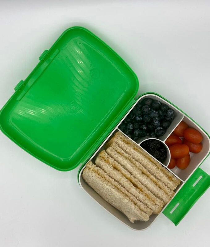 NjaNja gezonde lunchbox op school geleverd: Njanja-brooddoos-boterham huisgemaakte confituur rode vruchten-kerstomaten-blauwe bessen-rozijnen-schuin