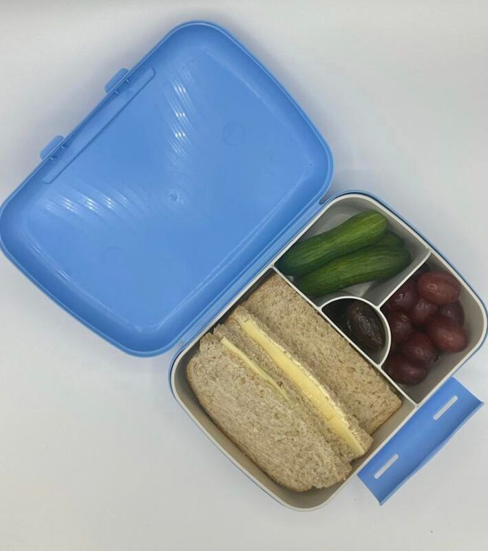 NjaNja gezonde lunchbox op school geleverd: Njanja-brooddoos-boterham kaas-komkommer-druiven-dadel-schuin