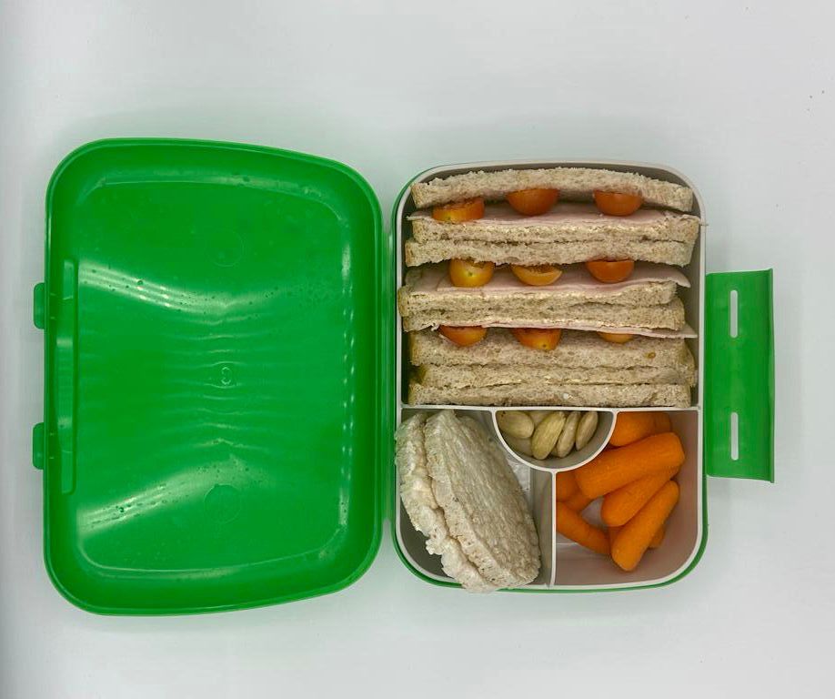 NjaNja gezonde lunchbox op school geleverd: Njanja-brooddoos-boterham kalkoenfilet en tomaat-wortel-rijstcrackers-amandelen-recht