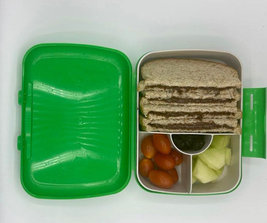 NjaNja gezonde lunchbox op school geleverd: Njanja-brooddoos-boterham notenpasta-kerstomaten-meloen-rozijnen-recht