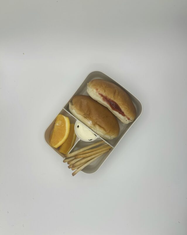 njanja brooddoos-sandwich hotdogworstje-sandwich aardbeiconfituur-sinaasappel-grissini-smeerkaas-schuin