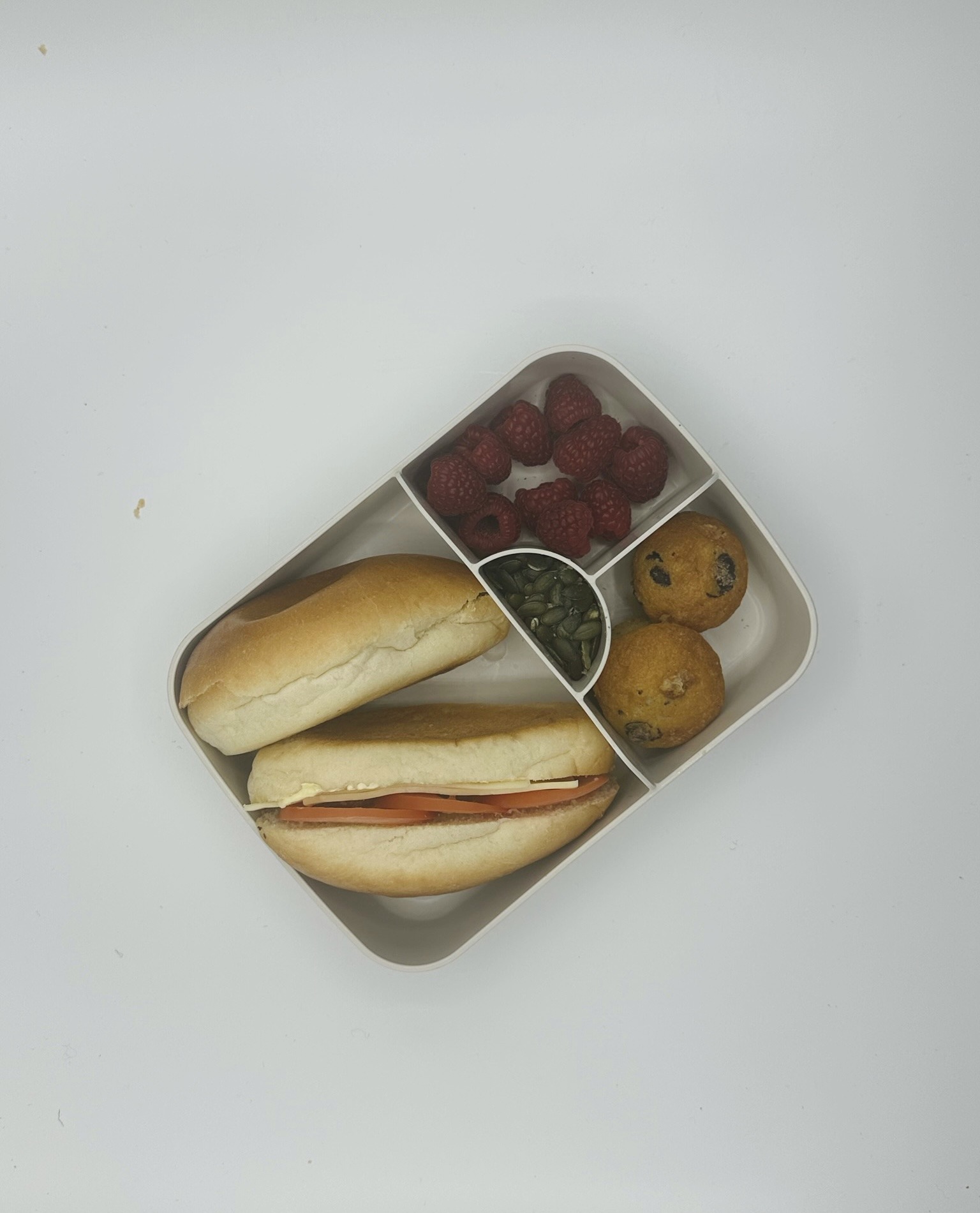 Sandwich kaas en tomaat + sandwich abrikozenconfituur, mini muffin, rood fruit, zonnebloempitten